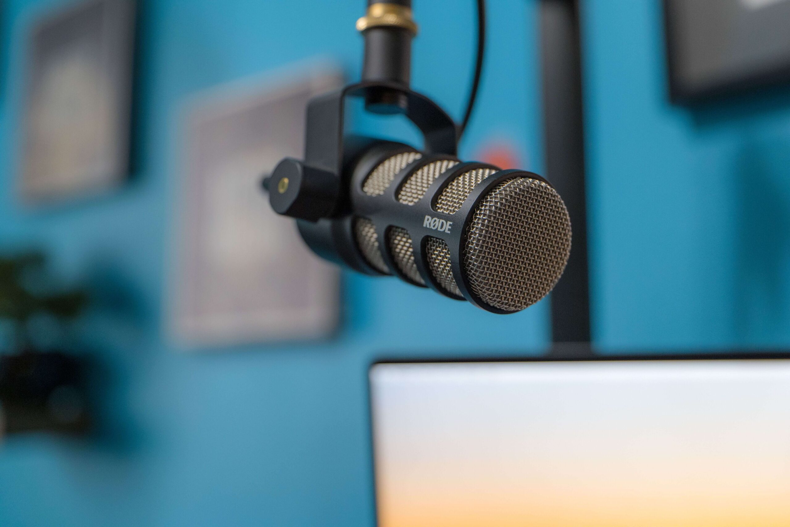 Blog featured image, shows hanging microphone with a computer screen in the background.